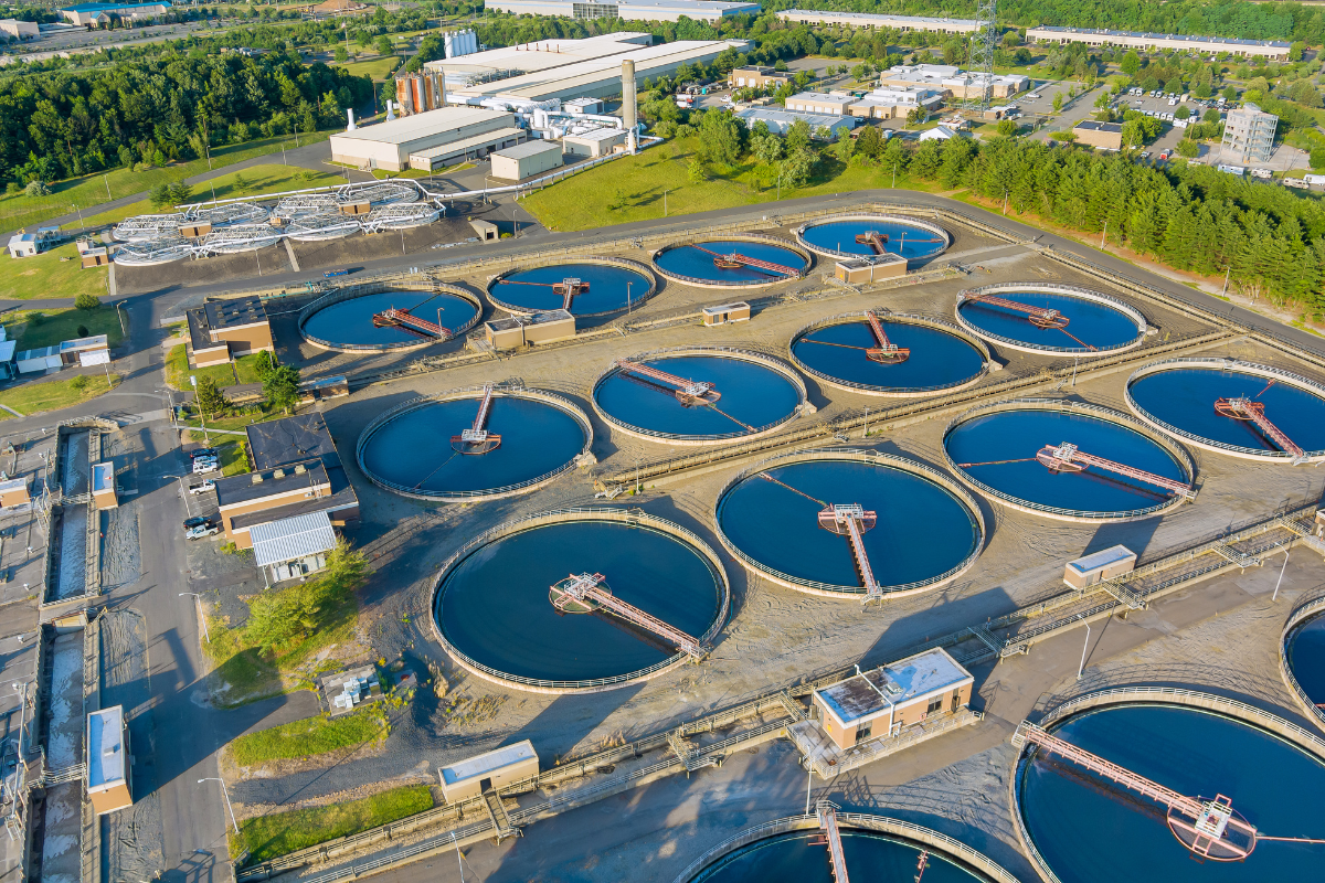 Aerial view of a septic wastewater treatment plant with circular sedimentation tanks.