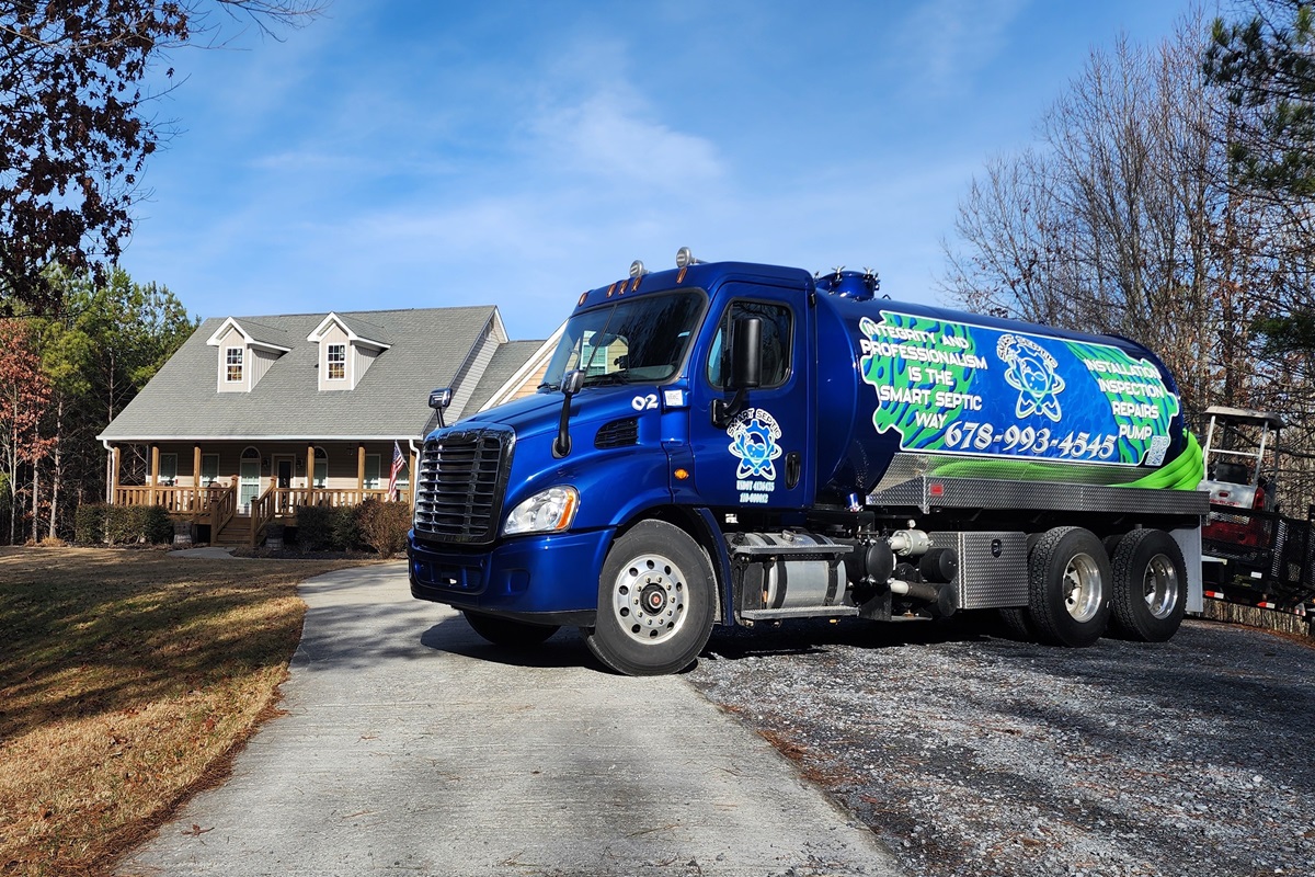 Septic service truck, specialized in septic vs sewer systems, parked on a residential driveway.