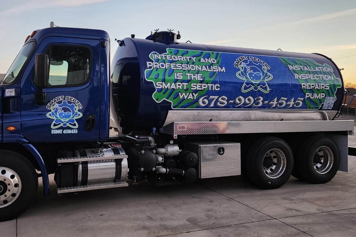 Blue septic service truck with text reading "Integrity and Professionalism is the Smart Septic Way" and displaying a phone number 678-993-4545. The truck offers installation, inspection, repairs, and pumping services, essential for your home renovation needs.