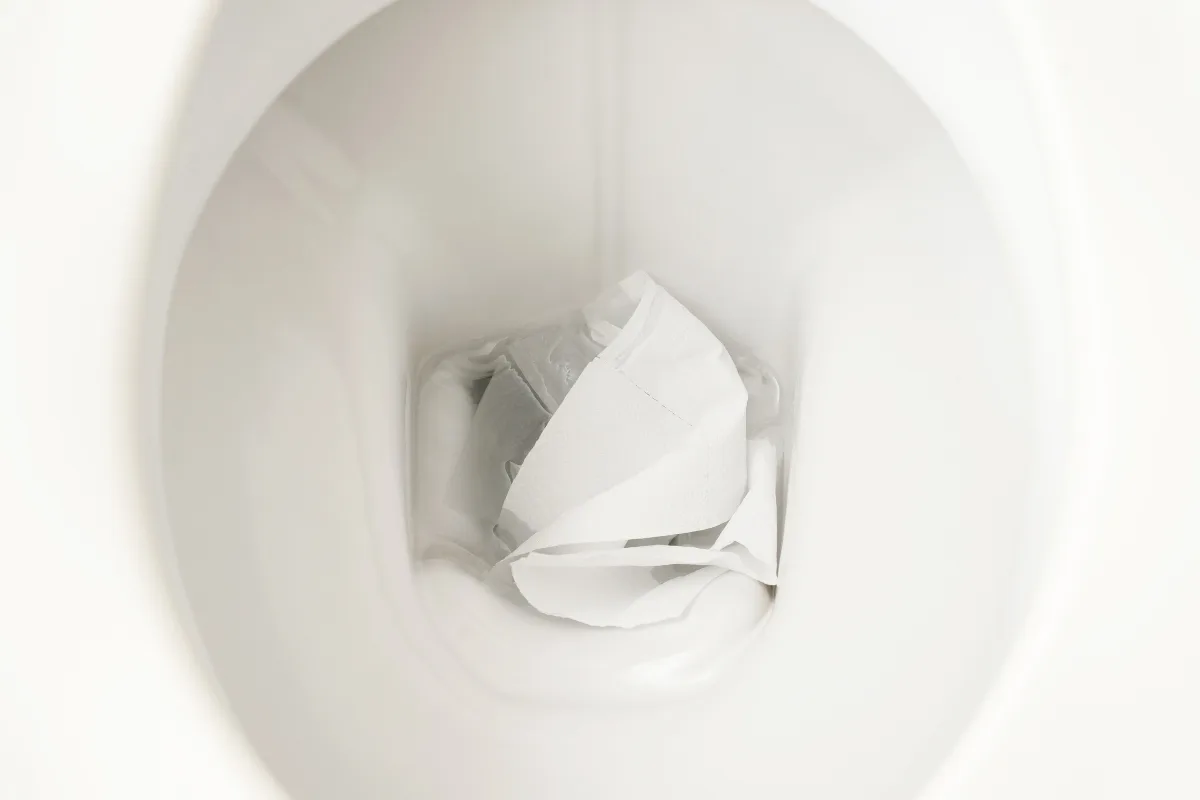 Eco-Friendly Septic Tank Cleaning: A Sustainable Approach 7 A close-up of a white ceramic toilet bowl with used toilet paper inside, highlighting the importance of regular septic tank cleaning.