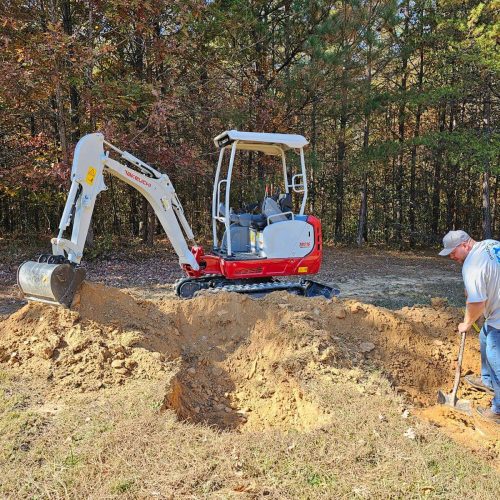 A man is digging a hole with an excavator.