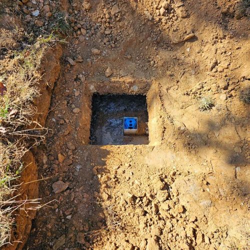 A hole in the ground with a blue box in it.