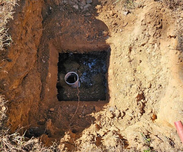 A hole in the ground with a pipe in it.
