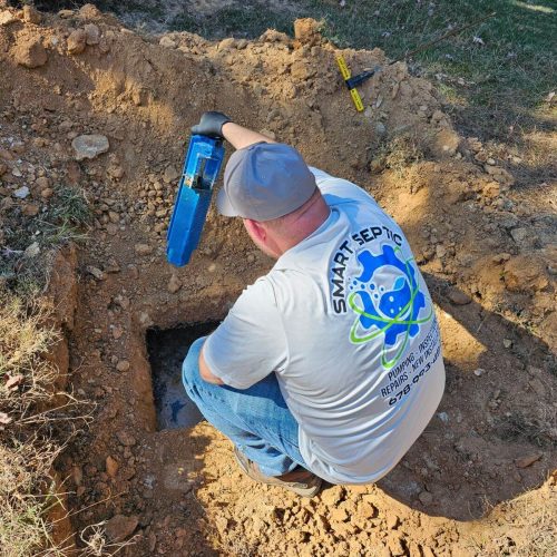 Georgia Service Areas 12 A man working on a hole in the ground providing emergency Georgia septic tank repairs.