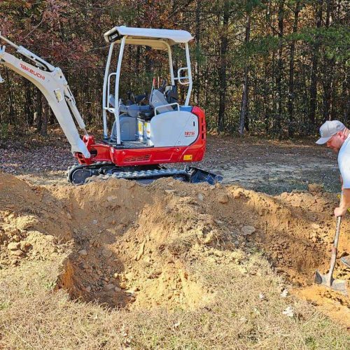In Roswell, a man is digging a hole with a red excavator.